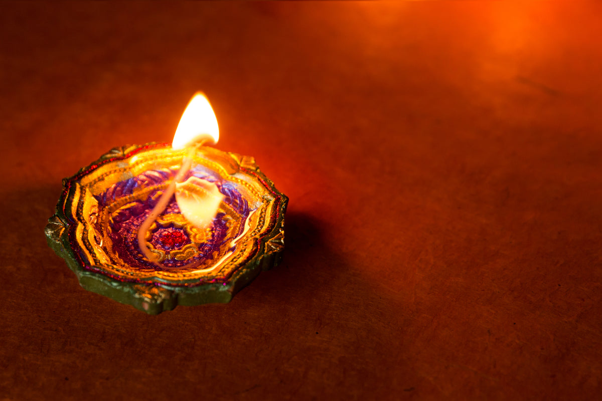 A flower-shaped diya lamp glowing softly for Diwali